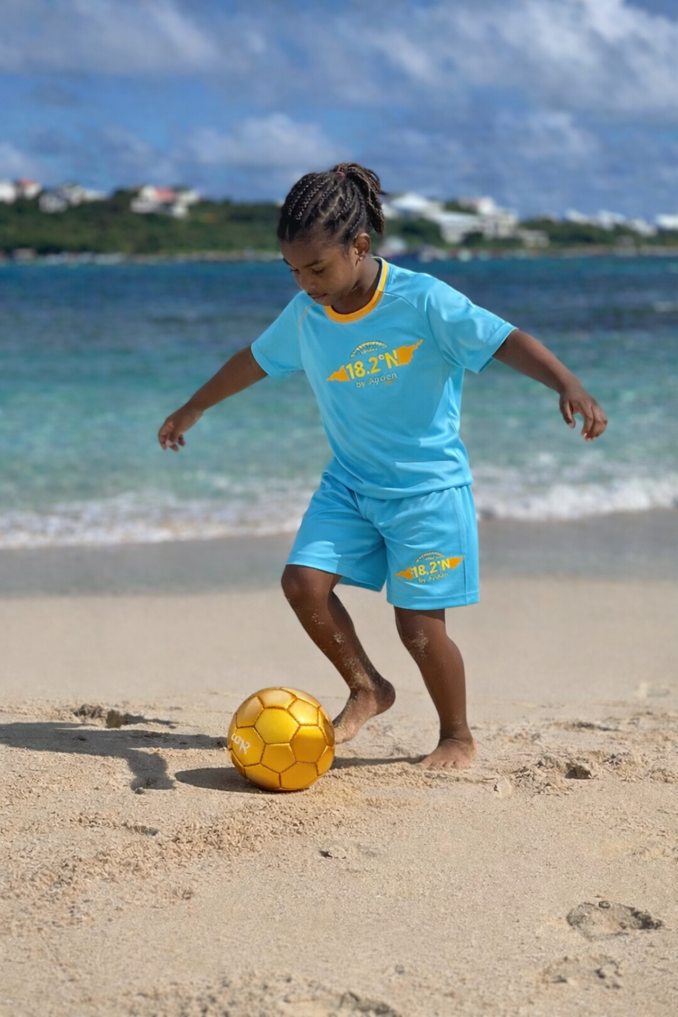 Ayden on the beach in turquoise sportswear